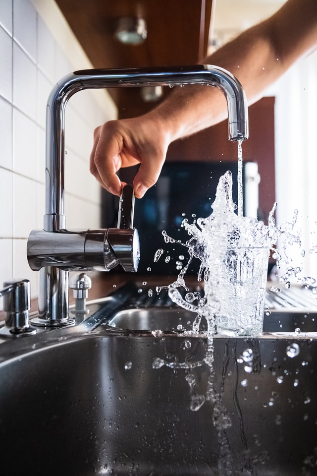 guy pouring a glass of splashing water